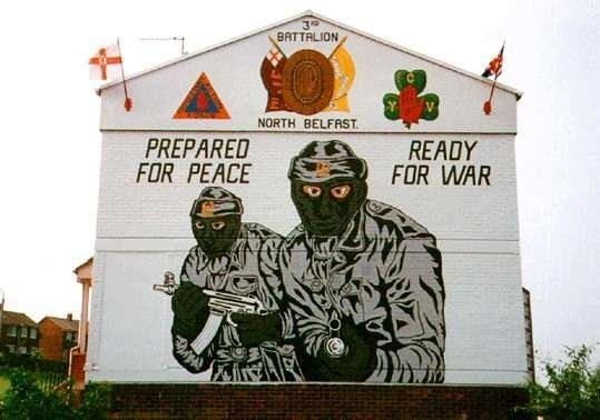 Noch heute erinnern die Murals in Belfast an den Nordirland-Konflikt. Dieses Wandgemälde mit den Paramilitärs der Ulster Volunteer Force wurde 2004 aufgenommen. (Wikimedia Commons, Lasse1974, Glenbryne, CC0 1.0)