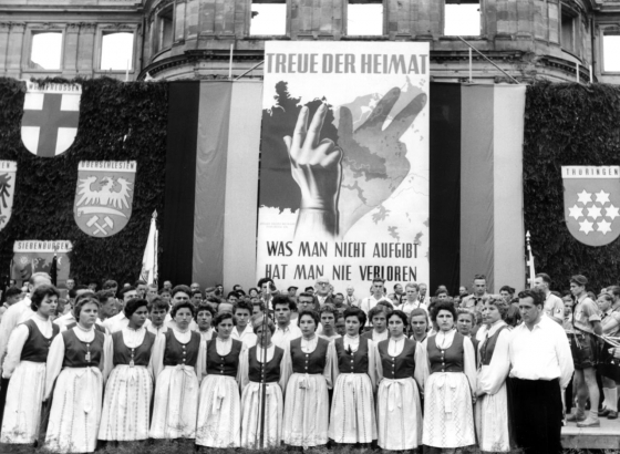 Heimatvertriebene in Stuttgart, Juli 1955: Auf einer »Treuekundgebung« füllen Trachtengruppen die Bühne, um ihre Verbundenheit mit der »verlorenen« Heimat und ihren fortdauernden Anspruch auf diese zu demonstrieren. In Polen hingegen war von den »wiedergewonnenen« Gebieten die Rede. (picture-alliance/Adolf Castagne)