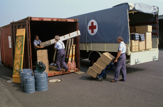 Mitarbeiter des Deutschen Roten Kreuzes beim Beladen eines Containers mit Hilfsgütern, die im Juli 1986 aus dem Münsterland nach Äthiopien geschickt wurden. Die westdeutsche Hilfe erscheint hier als ein wohlorganisierter Akt mit eingespielter Logistik.  (picture-alliance/dpa/Franz-Peter Tschauner)