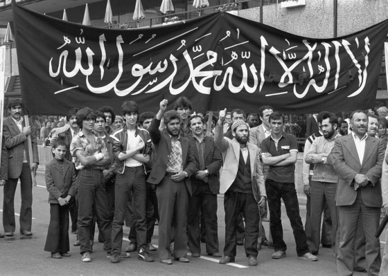 A group of Turkish Islamist men during a Milli Görüş demonstration in West Berlin, Breitscheidplatz, presenting a banner of the Shahada (the Islamic confession of faith), 5 July 1980. With Turkish labor migration, discourse and practice of Islamist masculinity were carried from Turkey to the diaspora communities in Europe. In 1980, both Turkish and Iranian Islamists began a series of demonstrations calling for a reestablished Muslim rule over Jerusalem (Küdüs/al-Quds). Such demonstrations practically manifested the general framing of resistance of ›real Muslim‹ men against the West, cultural imposition, imperialism, Zionism, and internal enemies. (Paul Glaser [1941–2022]/Süddeutsche Zeitung Photo)