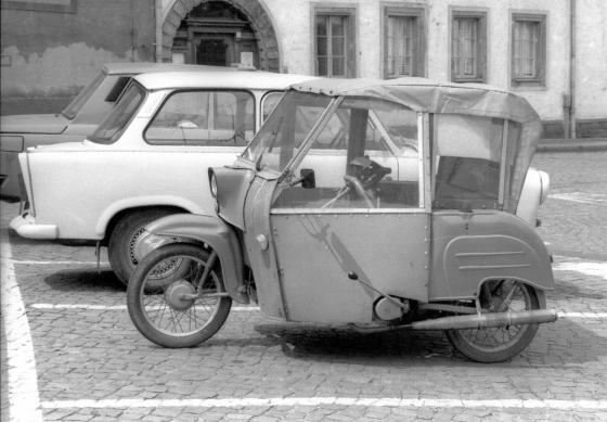 Ein »Krause-Duo«, ein »Versehrtenfahrzeug« mit Bauteilen des Mopeds Simson Schwalbe, auf einem Parkplatz in Karl-Marx-Stadt. Das Fahrzeug verfügte über keinen Rückwärtsgang.  (picture-alliance/zb/Paul Glaser [1941–2022]; Foto von 1990)