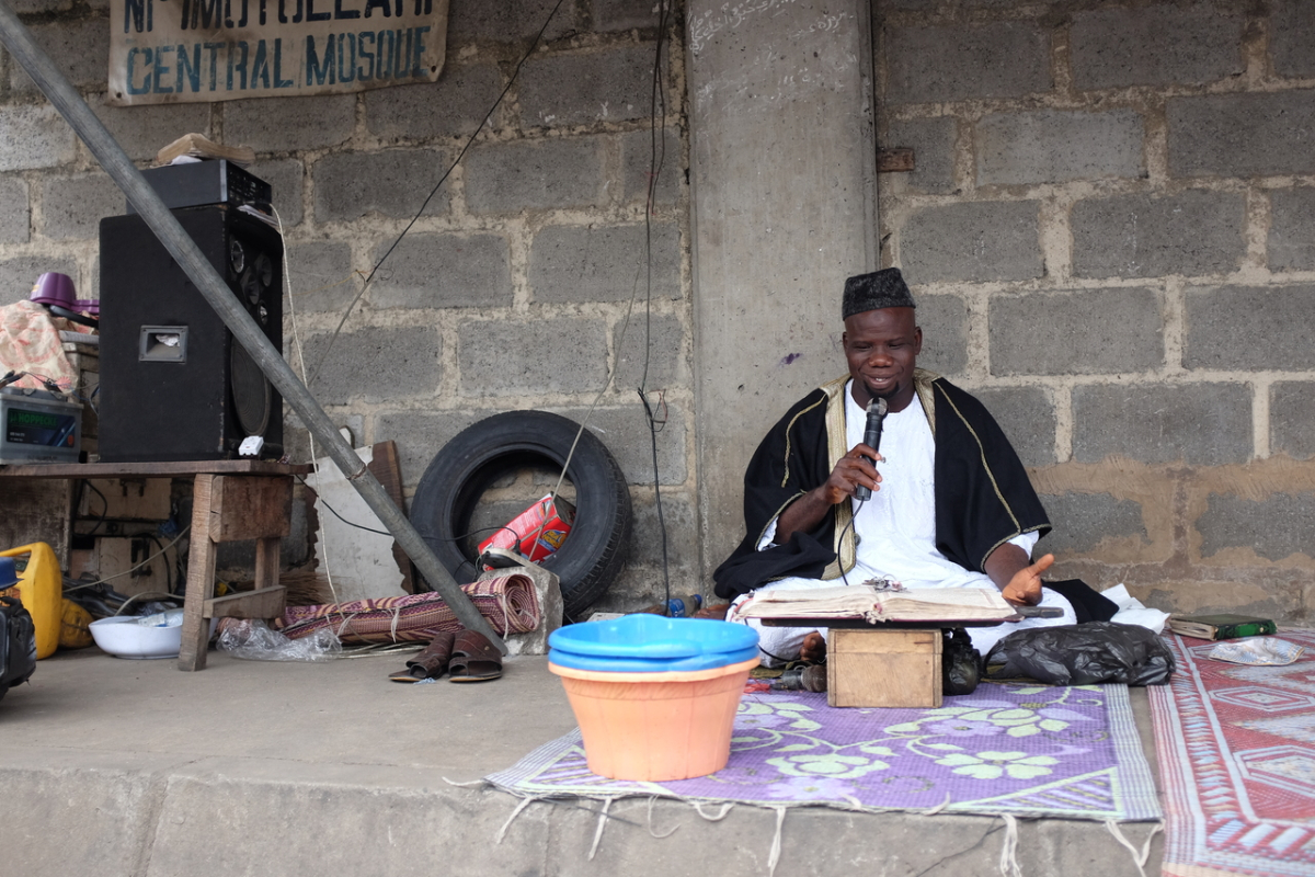A cleric reciting at Idumota market, Lagos, 2015. Nigerian urban landscapes are saturated with religious sounds emanating from mosques and churches, itinerant preachers, processionals carrying portable bullhorns, and cars with large speakers fixed to the top relaying Christian and Muslim preaching. (photo: Brian Larkin)