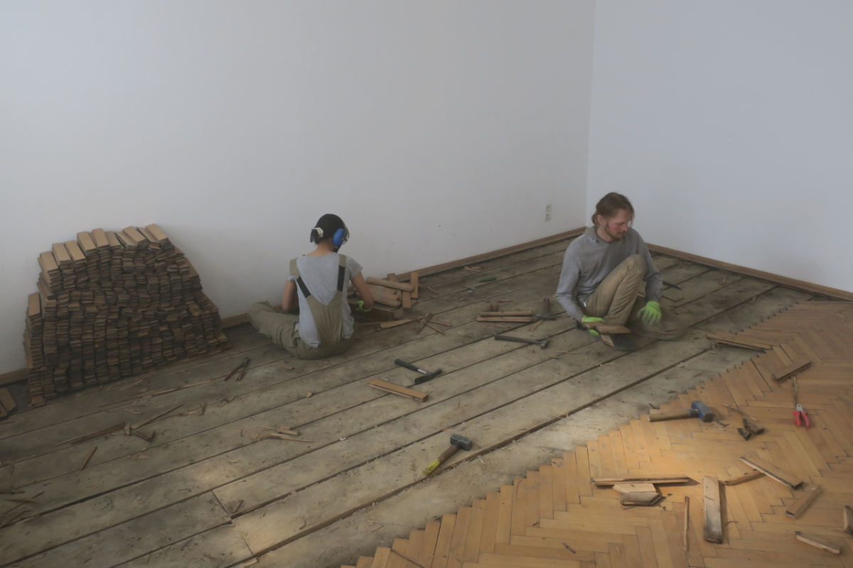 Manual salvaging of individual parquet slats from a Gründerzeithaus (tenement housing from the 19th century) in Vienna’s inner-city district. The slats will be refurbished by the industrial producer before being reintegrated into new buildings. (photo: Madlen Kobi, 2022)