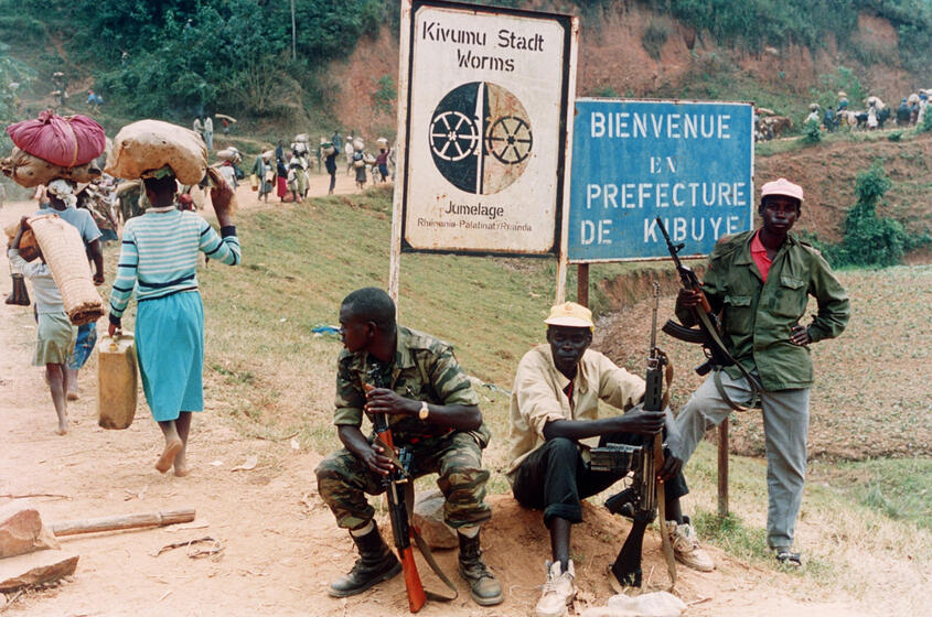 Im Bild beobachten Angehörige der Regierungstruppen im Juli 1994 die Flucht Hunderttausender Menschen, die aus Angst vor den heranrückenden Rebellen der Rwandan Patriotic Front (RPF) Richtung Westen zogen.