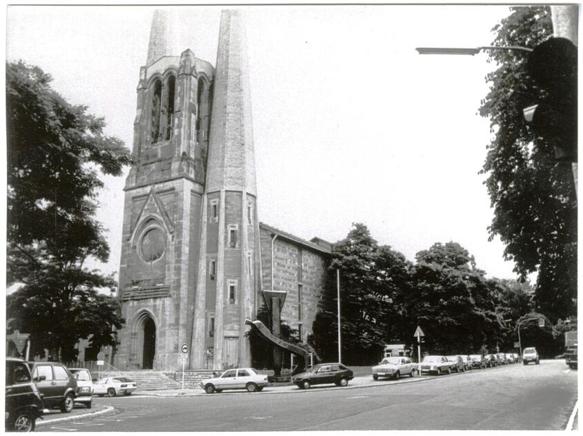 Würzburger St. Johannis-Kirche mit dem Denkmal Tod durch Bomben im Vordergrund