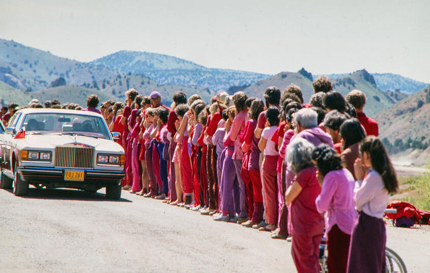 Bhagwan fährt 1984 in Rajneeshpuram in Oregon mit einem seiner Rolls-Royce an Anhänger:innen vorbei