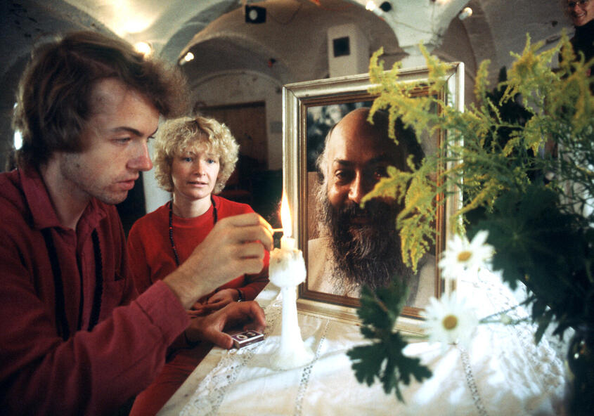Vor Beginn der Meditation zündet ein Sannyasin eine Kerze an (Bhagwan-Zentrum im bayerischen Margarethenried, 1981).